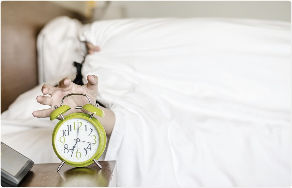 Night owl reaching for alarm clock