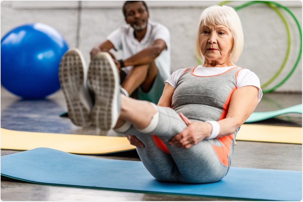 Older woman doing pilates, a form of exercise.