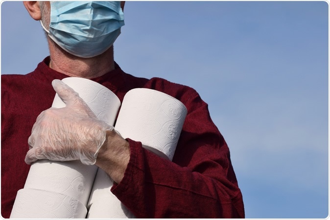 A male community volunteer carrying toilet rolls as he delivers essential supplies to vulnerable and elderly people self isolating during the Coronavirus Covid-19 pandemic. Image Credit: Amani A / Shutterstock