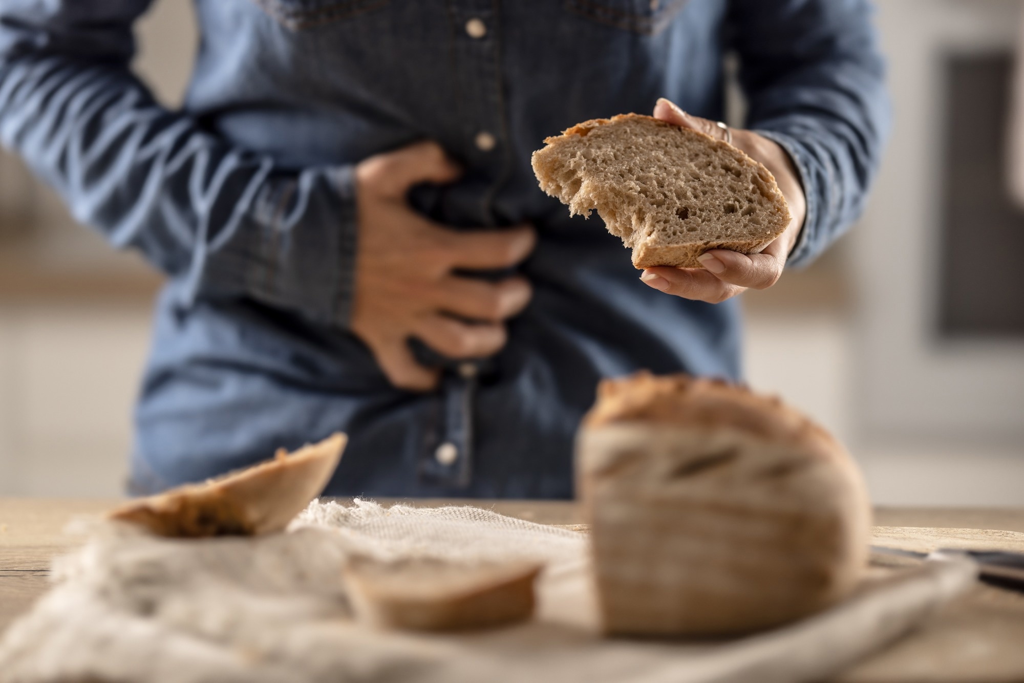 A young celiac woman suffers from abdominal pain after eating fresh bread