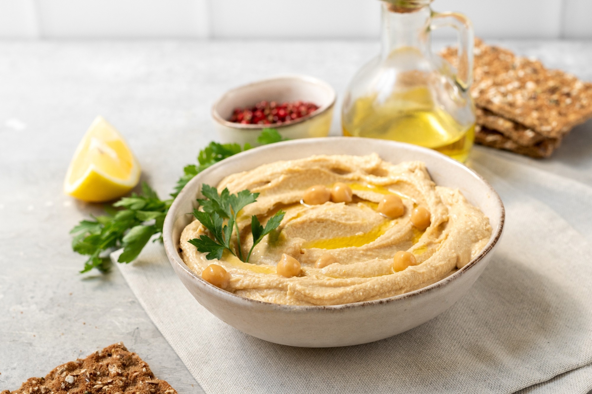 Fresh hummus with chickpea olive oil and lemon with multigrain crackers