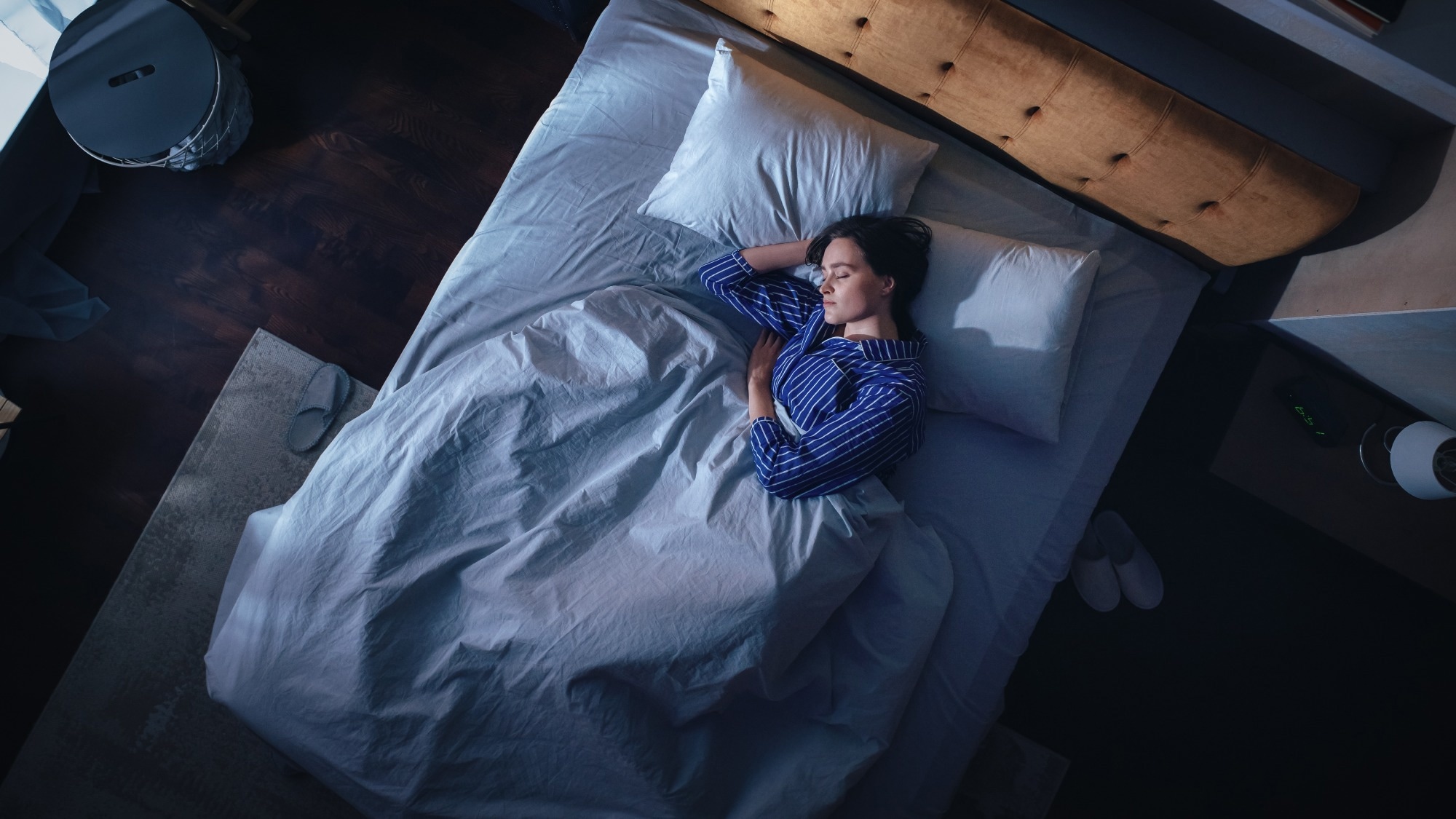 Top View of Young Woman Sleeping on a Bed in Her Bedroom at Night