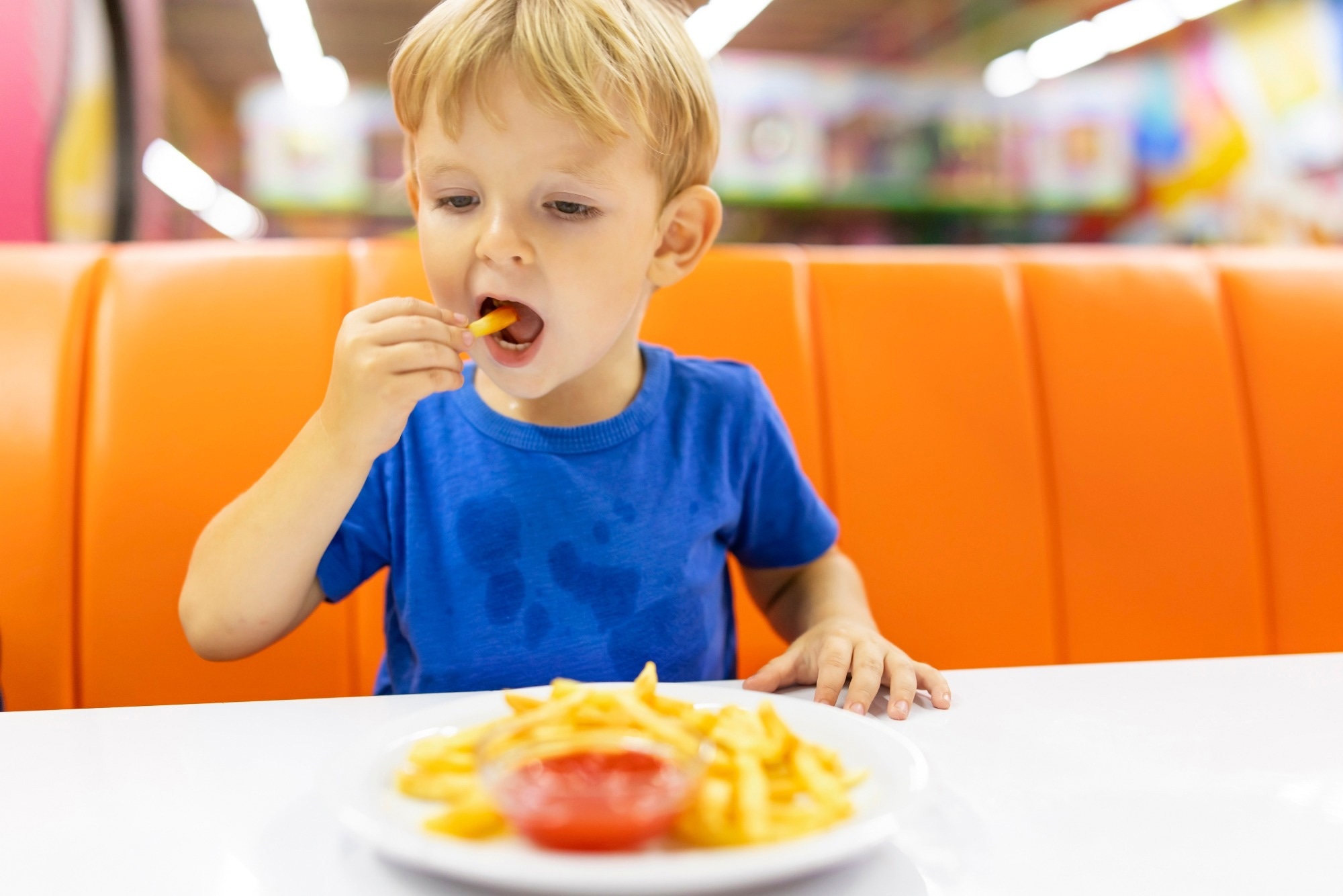 child eating french fries with sauce