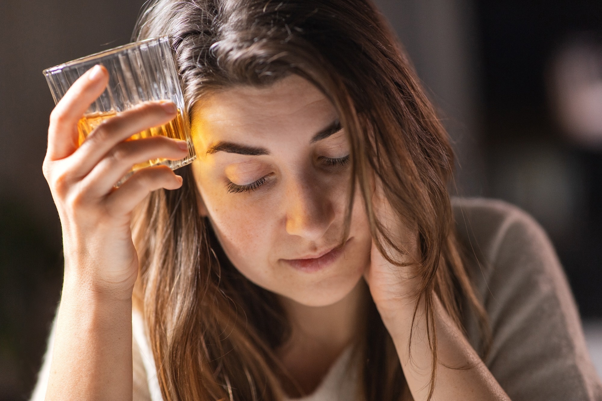 female alcoholic drinking whiskey at home